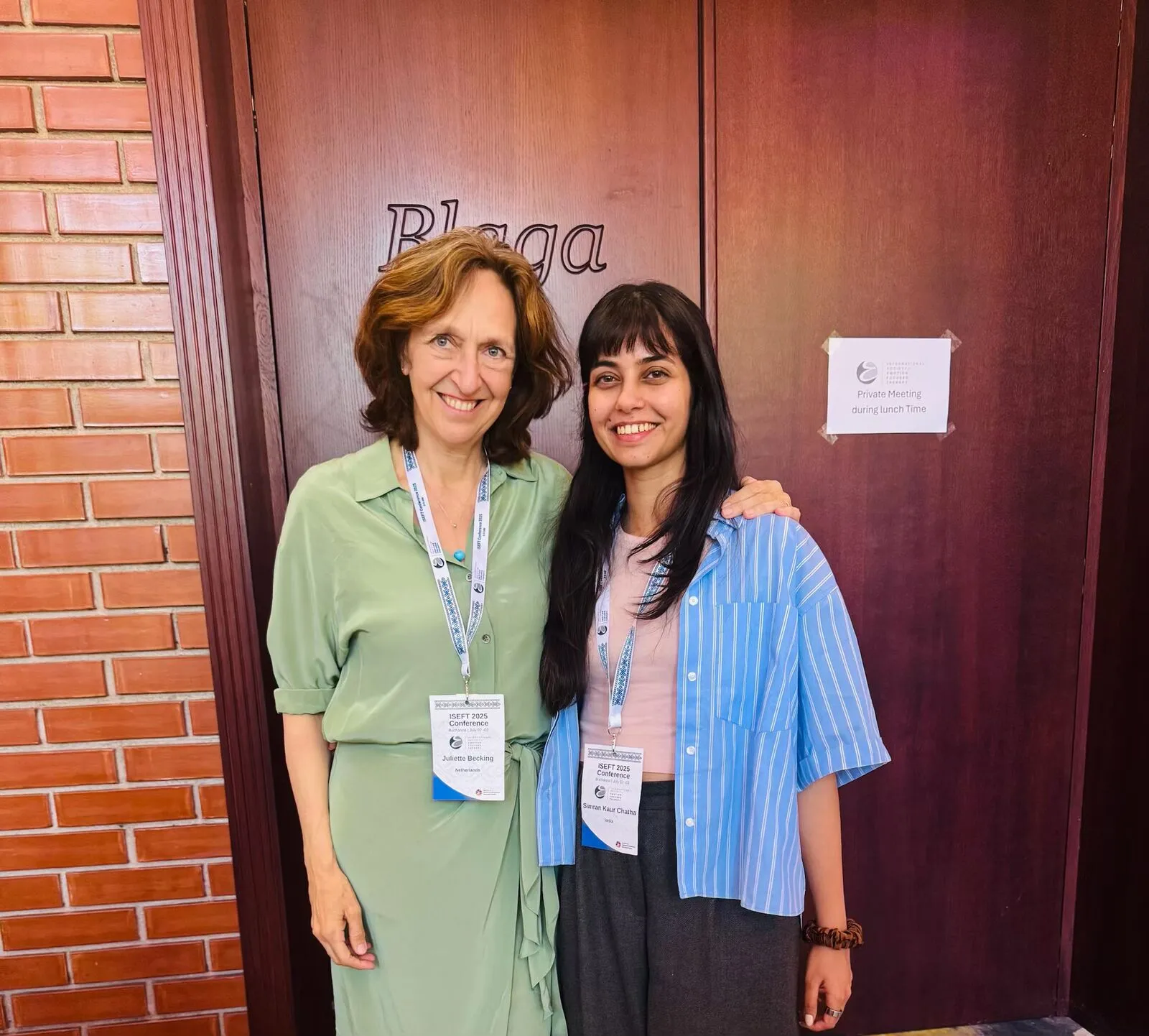 Two women with conference lanyards standing together