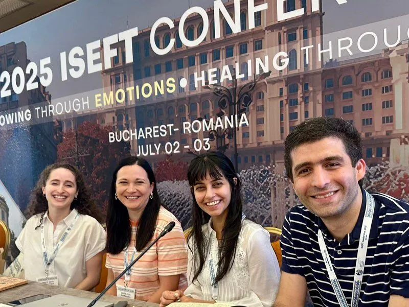 Four smiling delegates seated at a table at the 2025 isEFT Conference